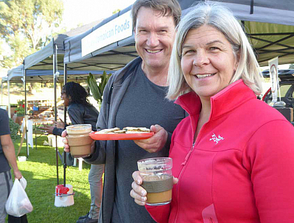 Lucie and her husband with reusable cup and plate at local farmers market