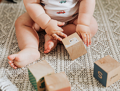 Baby playing with plastic free wooden blocks