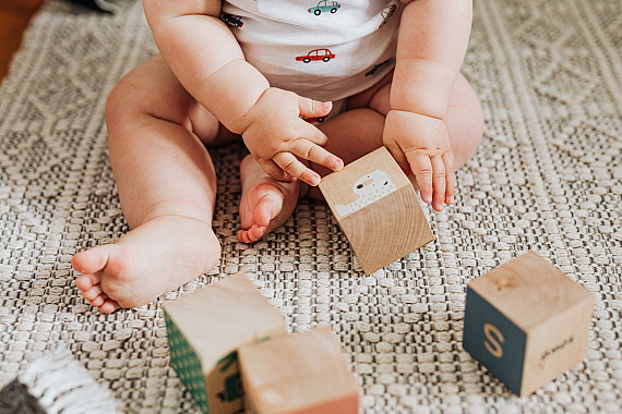 Baby playing with plastic free wooden blocks